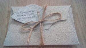 Envelope exclusivo cor branca feito em Papel Semente Fratos com amarra externa de barbante de rami e tag com dedicatória